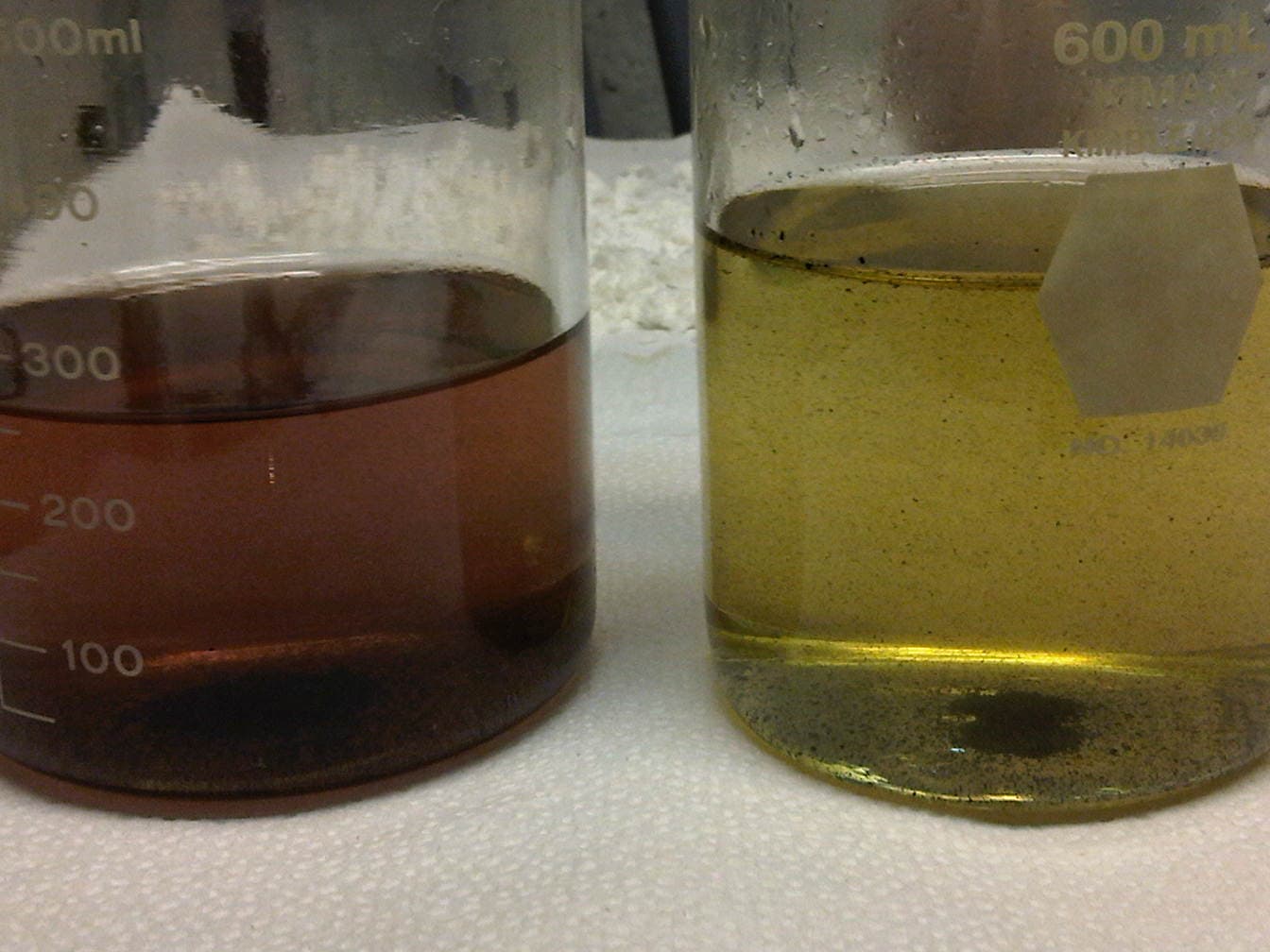 Before/after beakers — dark iron-laden produced water clarified to clear yellow with OC 360.