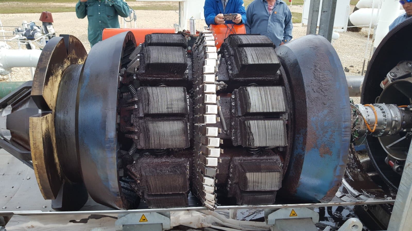 Multistage pump opened on site, internals heavily fouled with iron-sulphide solids — the kind of produced-water system Shale Chem treats.
