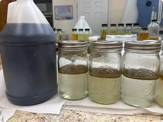 Lab bench jar tests showing clarified water beside concentrated OC-series coagulant.