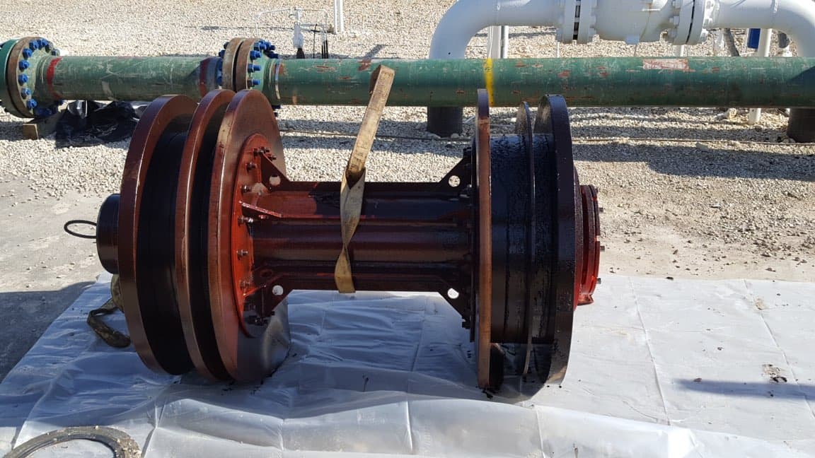 Clean gauge pig and ILI tool on a tarp in front of the restored 36-inch pipeline.