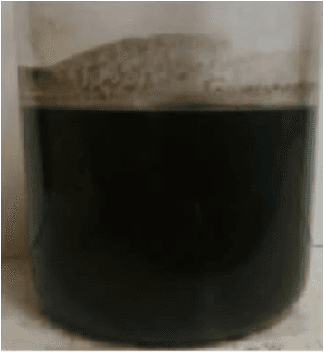 Raw SWD influent — black, solids-laden produced water before treatment.